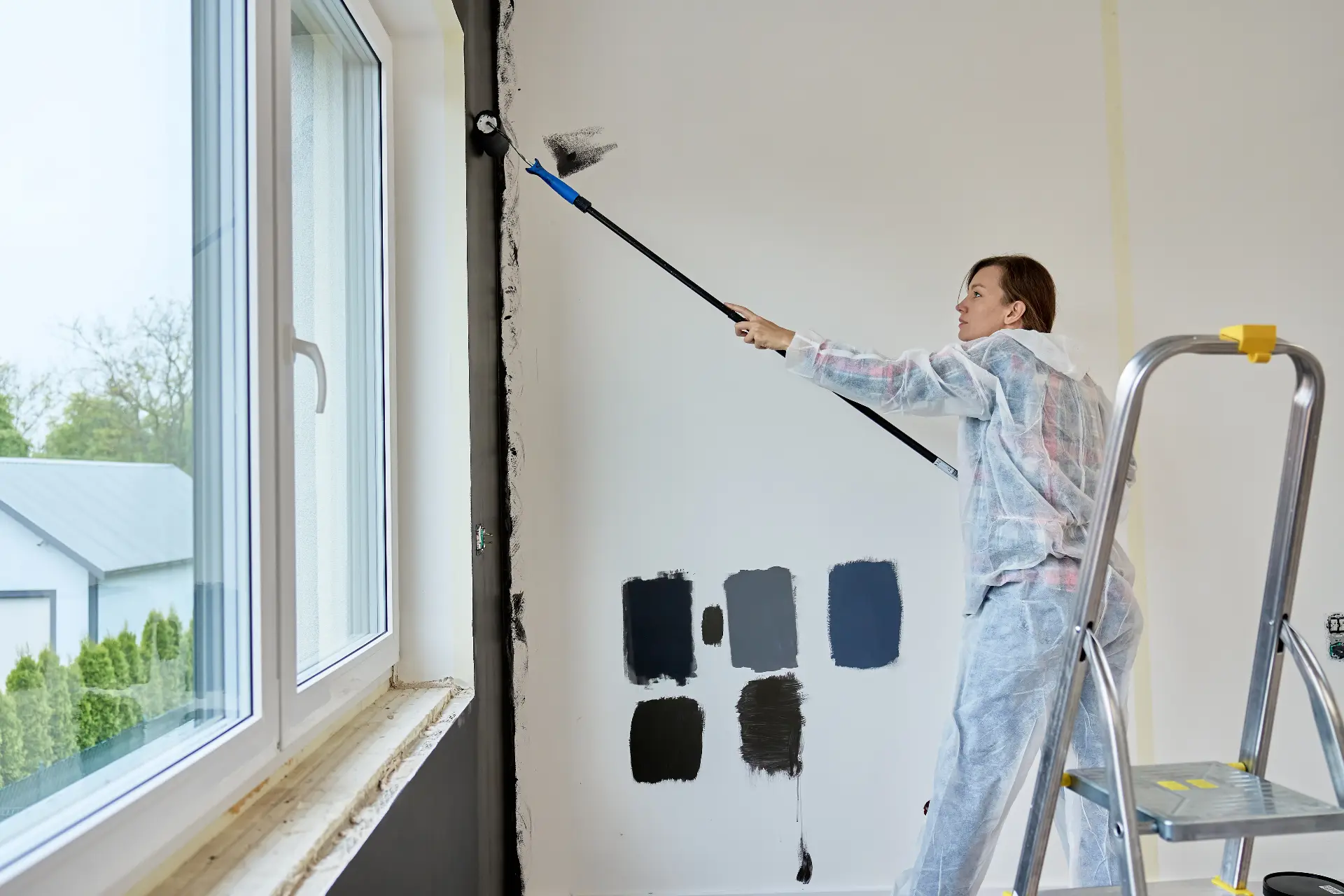 Professional painter rolling fresh paint on a wall